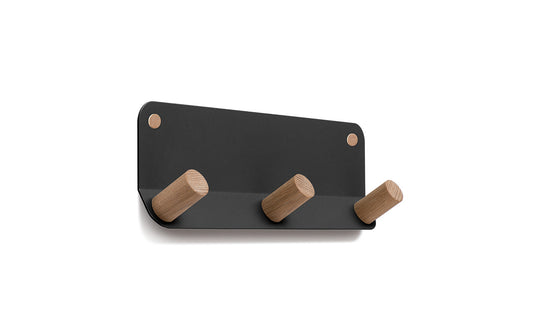 The Plane 3 Wall Hook by Fire Road is a sleek black wall-mounted coat rack featuring three wooden pegs and a durable frame made of powder-coated steel.