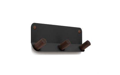 The Plane 3 Wall Hook by Fire Road features a powder-coated steel backplate and three brown wooden pegs.