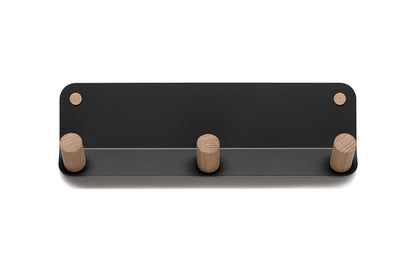 The Plane 3 Wall Hook by Fire Road is a wall-mounted coat rack with a rectangular black base and three cylindrical wooden pegs. Its sleek design features powder-coated steel construction for durability and modern appeal.