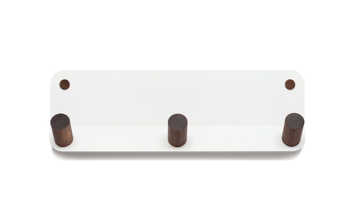 The Plane 3 Wall Hook from Fire Road is a white wall-mounted coat rack crafted from powder-coated steel and featuring three wooden pegs.