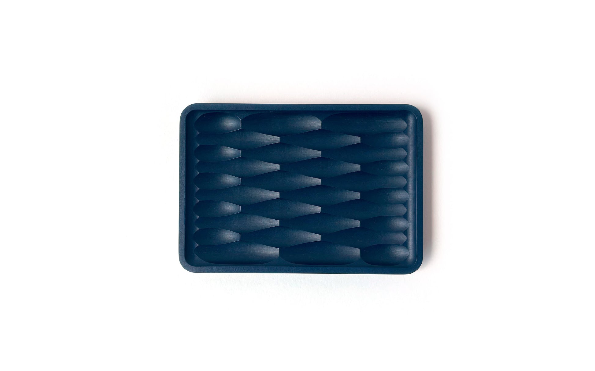 Rectangular dark blue rubber Deco Soap Dish by Fire Road with an interwoven, concave surface pattern on a white background, doubling as a sustainable bathroom accessory.