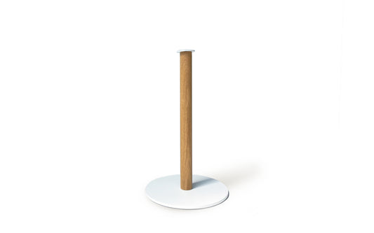 The Plane Paper Towel Holder by Fire Road features a wooden paper towel holder with a round white powder-coated steel base and a tall cylindrical wooden rod, made in the USA.