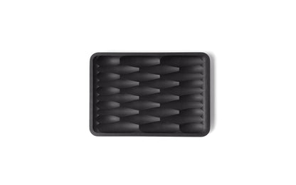 A black, rectangular tray with a geometric, interlocking diamond pattern, the Fire Road Deco Soap Dish adds a touch of elegance to any bathroom.